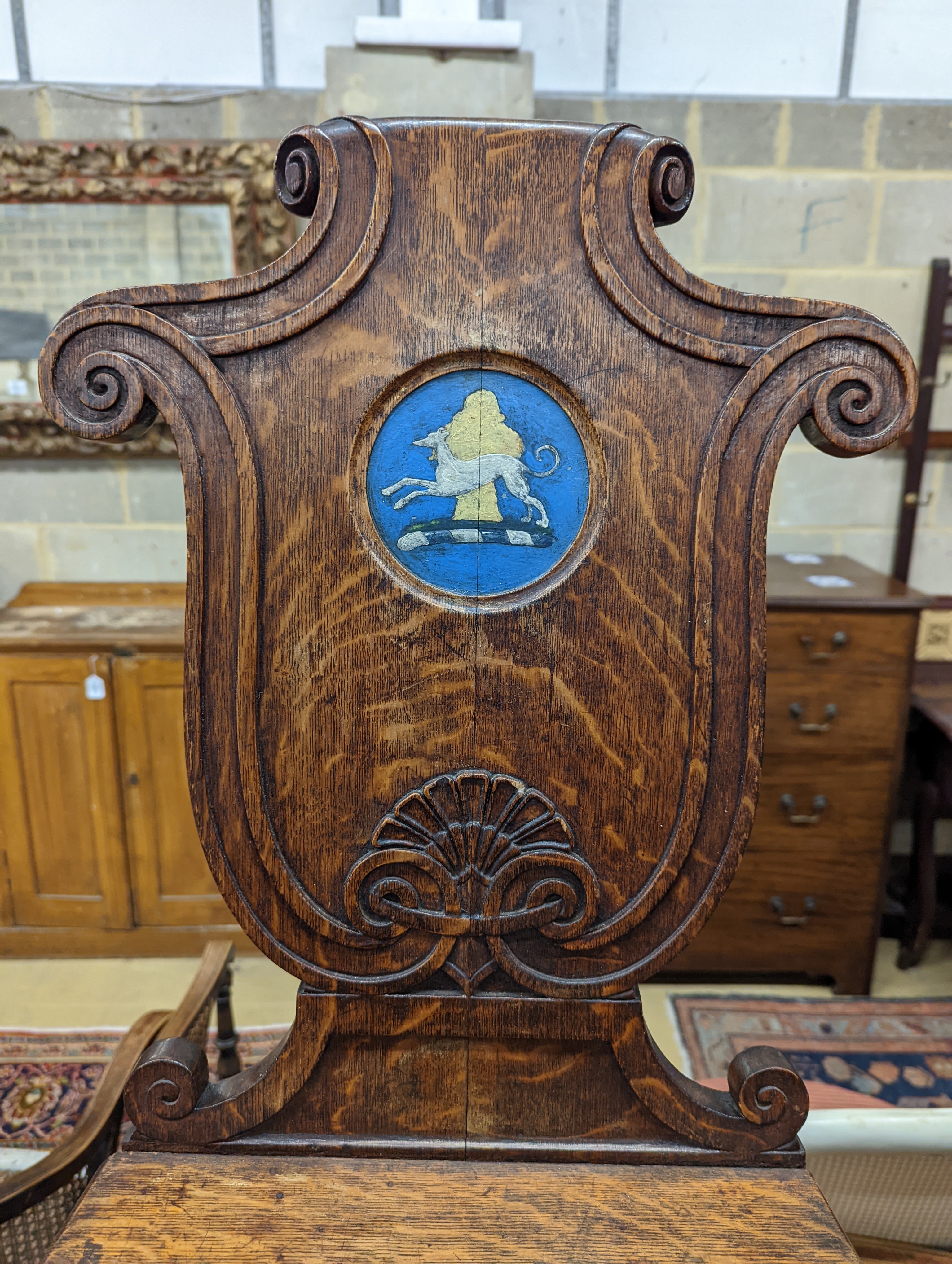 A pair of Victorian oak hall chairs with painted armorials, width 43cm, depth 39cm, height 94cm